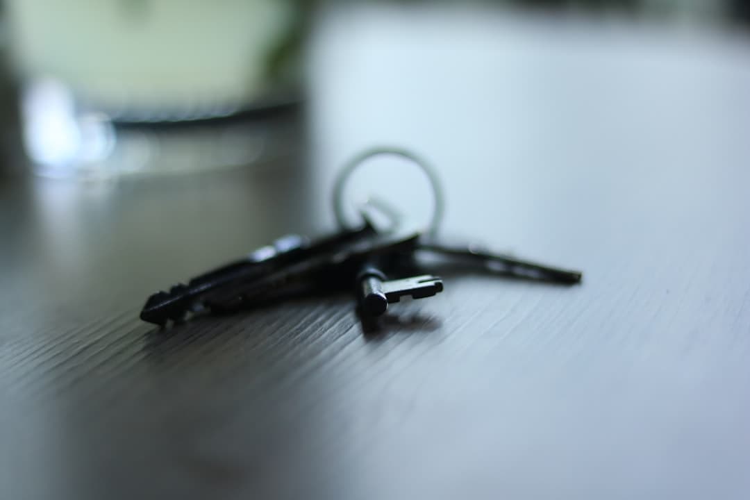 House keys resting on mortgage paperwork on a wooden desk.