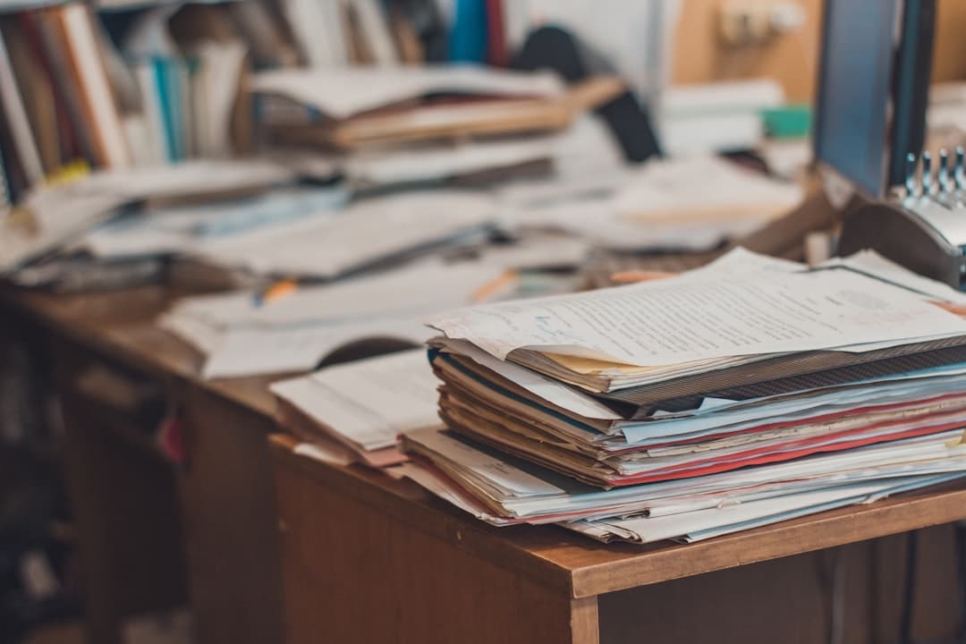 A stack of files organised on a clean desk.